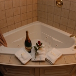 corner bathtub with a bottle of wine